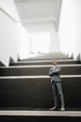 Geschäftsmann auf einer Treppe im Büro stehend - FLAF00098