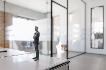 Geschäftsmann Figur stehend auf dem Schreibtisch im modernen Büro - FLAF00104