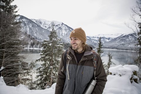 Glücklicher Mann in alpiner Winterlandschaft mit See, lizenzfreies Stockfoto