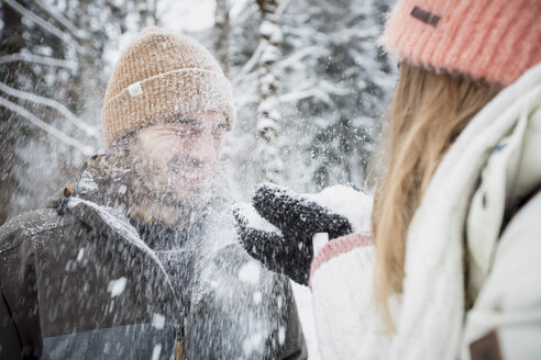 Glückliches Paar hat Spaß mit Schnee in Winterlandschaft - SUF00413