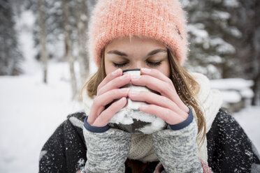 Junge Frau genießt ein heißes Getränk im Freien im Winter - SUF00417