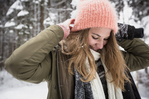 Lächelnde junge Frau im Freien im Winter - SUF00430