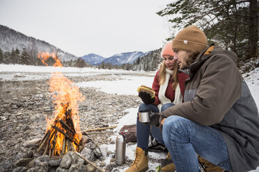 Pärchen auf einer Reise im Winter mit einer Pause am Lagerfeuer - SUF00445