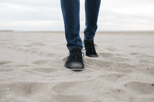 Beine eines Mannes, der am Strand spazieren geht - JRFF01517