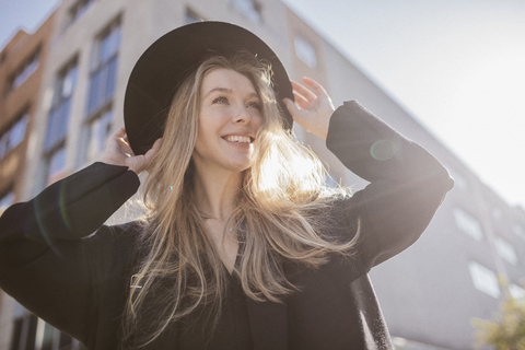 Portrait of happy woman with hat dressed in black stock photo