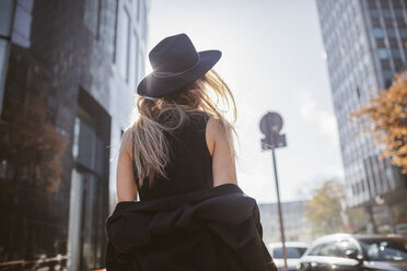 Rückenansicht einer schwarz gekleideten Frau mit Hut - KMKF00136