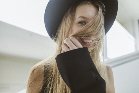 Portrait of laughing blond woman wearing black hat stock photo
