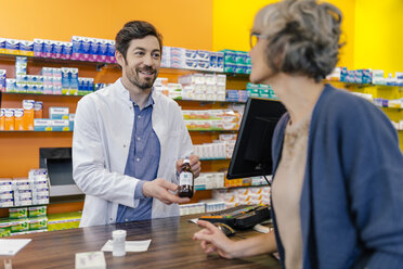Pharmacist explaining medicine to customer in pharmacy - MFF04278
