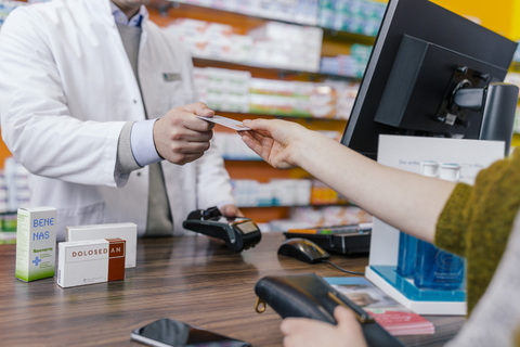 Kunde zahlt bargeldlos in einer Apotheke, lizenzfreies Stockfoto