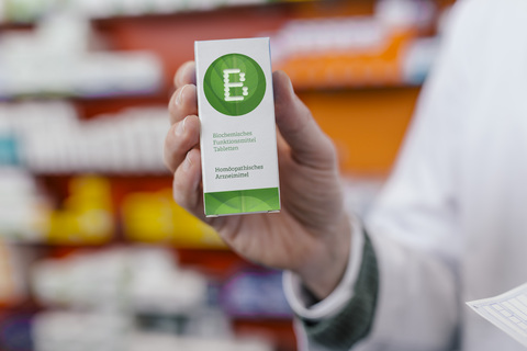 Pharmacist holding homeopathic medicine in pharmacy stock photo
