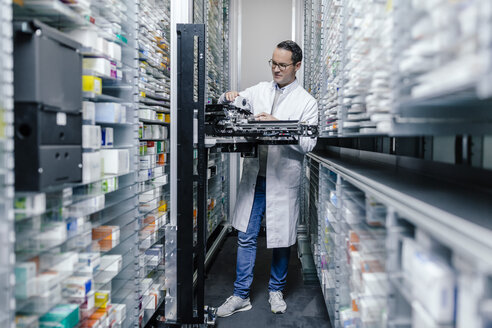 Apotheker bei der Prüfung einer Kommissioniermaschine in der Apotheke - MFF04354