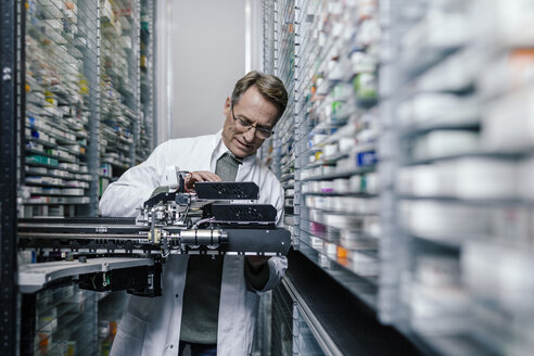 Apotheker bei der Prüfung einer Kommissioniermaschine in der Apotheke - MFF04358