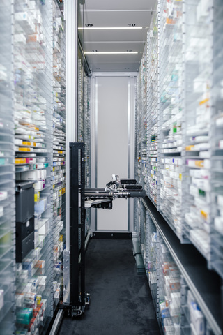 Medicine in shelves in commissioning machine in pharmacy stock photo