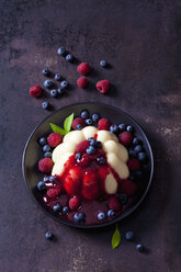Custard with raspberries, blueberries and raspberry sauce on plate - CSF28732