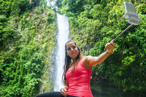 Costa Rica, Arenal Volcano National Park, Frau macht ein Selfie mit dem Wasserfall von La Fortuna - KIJF01853