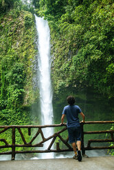 Costa Rica, Arenal Volcano National Park, Mann schaut auf den Wasserfall von La Fortuna - KIJF01854