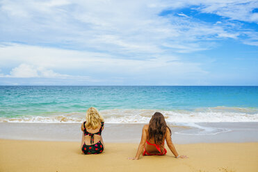 Panama, Bocas del Toro, Playa Bluff, Zwei Frauen in Bikinis sitzen am Strand - KIJF01864