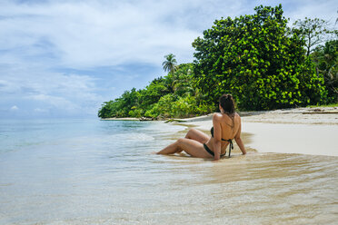 Panama, Bocas del Toro, Cayo Zapatilla, Woman sitting on the beach - KIJF01868