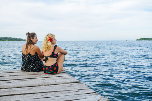 Panama, Bocas del Toro, Zwei Frauen sitzen auf einem Holzsteg - KIJF01874