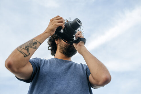 Panama, Bocas del Toro, Man with camera and camera tattoo on the arm - KIJF01878