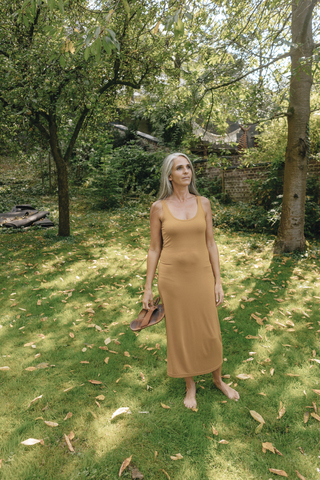 Frau steht barfuß im Garten und entspannt sich, lizenzfreies Stockfoto