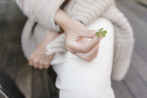 Woman's hand holding cloverleaf, close-up - KNSF03487