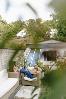 Frau mit Laptop entspannt auf Terrasse - KNSF03530