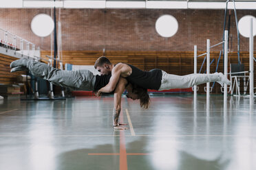 Zwei Männer machen Akrobatik in der Turnhalle - OCAF00005