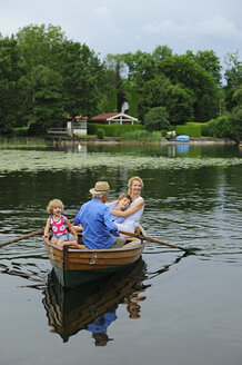 Glückliche Familie im Ruderboot auf dem See - ECPF00162