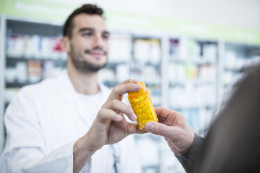 Nahaufnahme einer Apothekerin, die einem Kunden in einer Apotheke eine Pillenschachtel gibt - WESTF23940