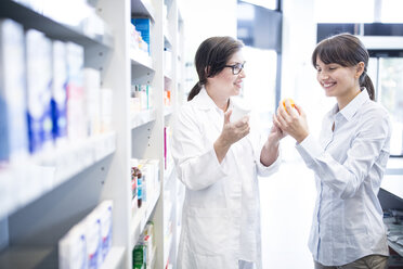 Pharmacist advising customer in pharmacy - WESTF23945