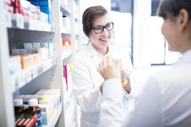 Pharmacist advising customer in pharmacy - WESTF23946