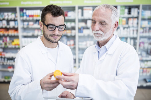 Zwei Pharmazeuten, die in der Apotheke Medikamente untersuchen - WESTF23953