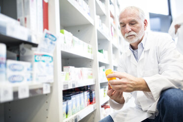 Apothekerin prüft Pillendose in der Apotheke - WESTF23954