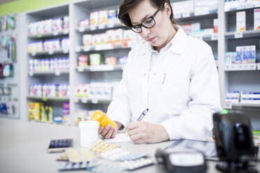 Apothekerin mit Medikamenten am Tresen in der Apotheke - WESTF23962