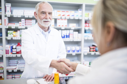 Apotheker und Kunde schütteln sich in der Apotheke die Hände - WESTF23965