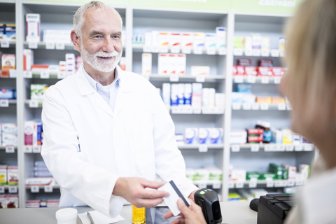 Kunde zahlt bargeldlos in einer Apotheke, lizenzfreies Stockfoto