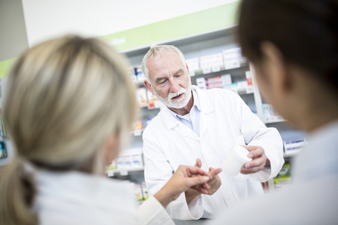 Apothekerin mit zwei Frauen in der Apotheke, lizenzfreies Stockfoto