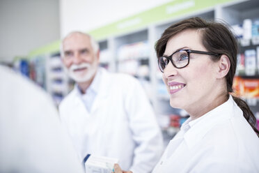 Smiling pharmacist with colleague in pharmacy - WESTF23985