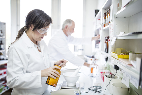 Mann und Frau arbeiten im Labor einer Apotheke, lizenzfreies Stockfoto