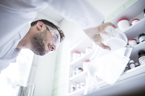 Mann arbeitet im Labor einer Apotheke, lizenzfreies Stockfoto