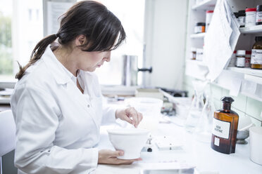 Woman preparing medicine in laboratory of a pharmacy - WESTF24024