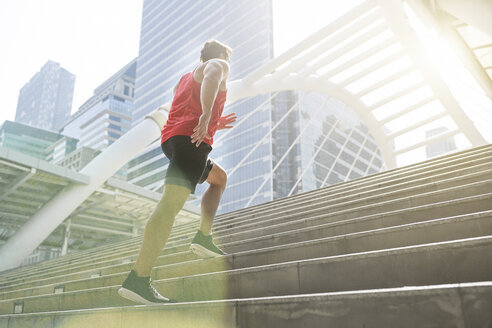 Man in red fitness shirt running upstairs in the city - SBOF01119