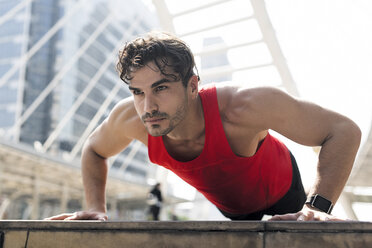 Athlete exercising push-ups in the city - SBOF01144