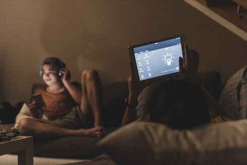 Couple relaxing on couch in smart home - UUF12515