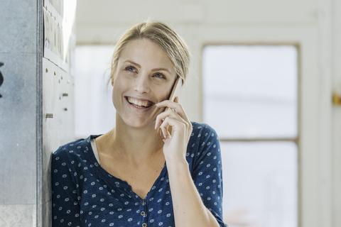 Porträt einer glücklichen jungen Frau am Telefon, lizenzfreies Stockfoto