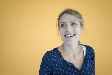 Portrait of laughing woman in front of yellow wall - JOSF02131