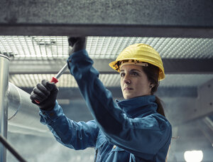 Handwerkerin mit Schutzhelm bei der Arbeit - CVF00028