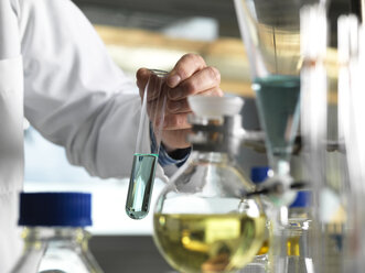 Wissenschaftler hält Reagenzglas während eines Experiments im Labor - ABRF00010