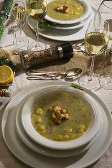 Knoblauchcremesuppe mit Croutons auf festlich gedecktem Tisch - MAEF12483